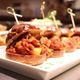 Field roast sausage & pepper sliders on pretzel buns with smokey chili aoili